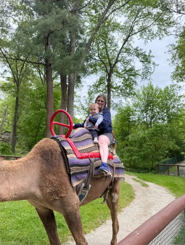Melanie Moon riding a camel with Brayden on her lap